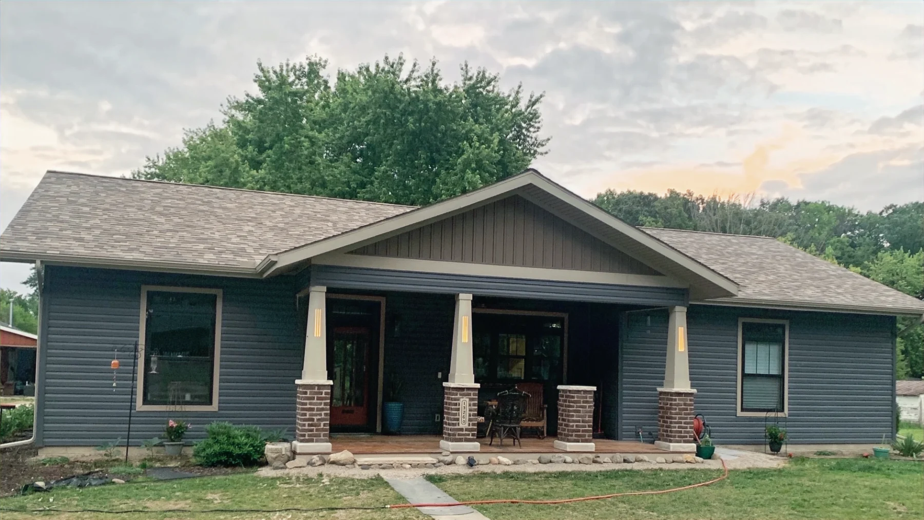 Blue house with a covered front porch and stone column bases